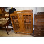 An oak and bevel glass display cabinet