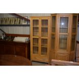 A light oak and glazed cabinet fitted single drawe