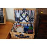 A wicker picnic hamper and contents