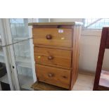 A pine bedside chest fitted three drawers