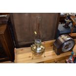 A brass oil lamp with glass chiminea