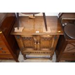 An oak linen fold decorated two door side cupboard