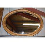 A gilt framed oval and bevel edged mirror