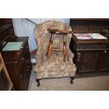 An 18th Century style wing back armchair raised on