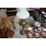 A brass oil lamp with milk glass shade