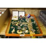 A tray of decorative costume brooches