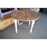 A circular topped pine coffee table