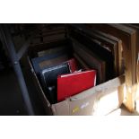 A box of mixed photo frames and prints