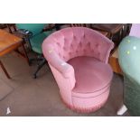 A pink upholstered tub chair