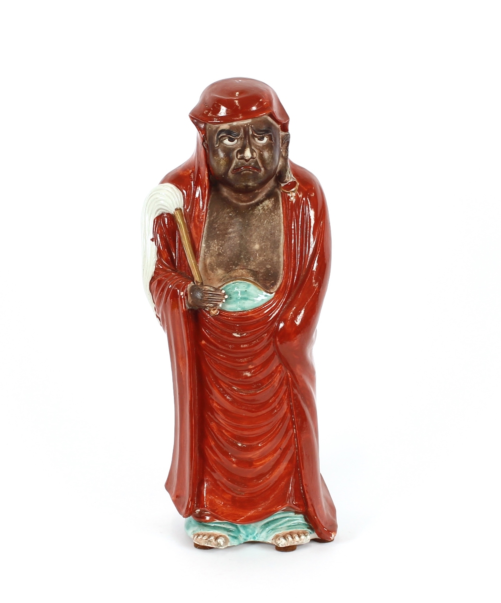 A Kutani figure of a man in a red cloak, carrying a fly swish, 37cm high