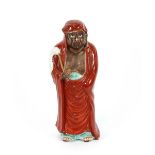 A Kutani figure of a man in a red cloak, carrying a fly swish, 37cm high