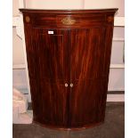 A George III mahogany and inlaid elliptical corner cupboard, decorated paterae and conch shell,