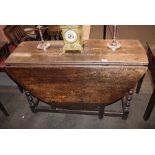 An Antique oak gate leg dining table, fitted single end drawer and raised on turned supports, 117cm
