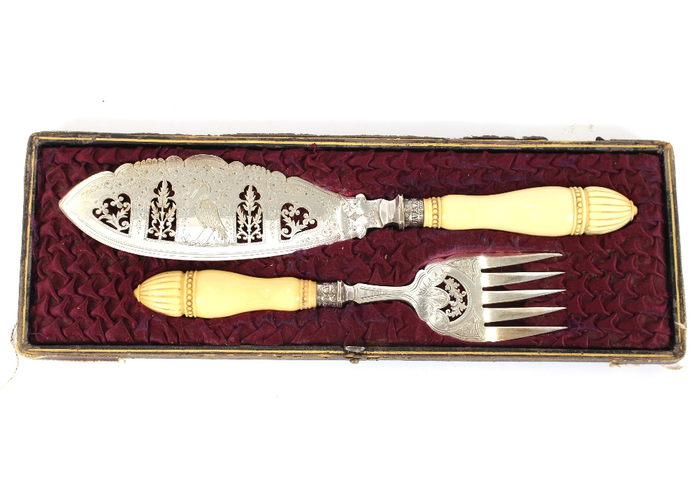 A cased pair of Victorian plated fish servers, having foliate engraved decoration and ivory handles