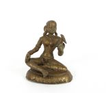 An Eastern bronze figure, of a seated Goddess holding a bird in her hand, 15cm high