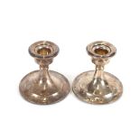 A pair of George V silver dwarf candlesticks, having loaded bases, 7.6cm high, Chester 1923