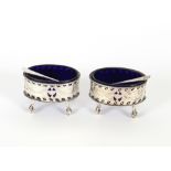 A pair of George III silver salts, having pierced sides and garland decoration, blue glass liners,