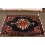 A Middle Eastern rug, having central floral panel with stylised borders on a predominately blue