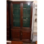 A late Victorian glazed oak gun display cabinet, enclosed by a pair of glazed panelled doors, raised