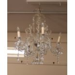 A cut glass chandelier, hung with prism drops and scrolled arms, (formerly Eton College)