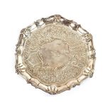 A George II silver salver, having pie-crust and shell decorated border, raised on three hoof feet