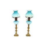 A pair of Victorian blue satin glass oil lamps and shades, raised on brass candlestick bases, 48cm