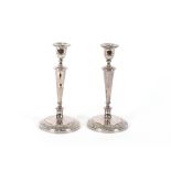 A pair of 19th Century plated candlesticks, with campana shaped sconces, raised on tapering