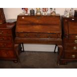 An Antique walnut and cross-banded bureau on stand, the fall front opening to reveal a concave