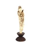 A late 19th/early 20th Century carved ivory figure, of an immortal, on hardwood stand, 27cm