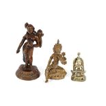 Three Tibetan and Indian Buddhist and Hindu brass and coppered and bronze figures