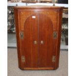 A Georgian oak hanging corner cupboard, enclosed by a pair of arched panelled doors hung to brass