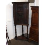 An Antique carved oak freestanding corner cupboard, fitted interior shelf and drawer, enclosed by