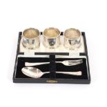 A cased silver fork and spoon, Birmingham 1961; three silver plated napkin rings; a silver tea