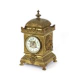 A 19th Century French ornate brass cased mantel clock, the circular white enamel dial supporting