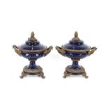 A pair of 19th Century style blue glazed gilt metal mounted urns and covers, surmounted by pineapple