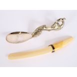 A Ceylonese white metal serving spoon, the scrolled handle with bird decoration; and an ivory and