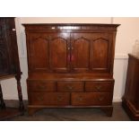 An 18th Century Welsh oak two section low press cupboard, enclosed by a pair of arched fielded