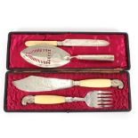 A pair of cased plated fish servers, with ivory handles; a silver cake fork; and a George III silver