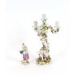 A 19th Century German porcelain candelabra, decorated with cherubs on a tree amongst floral