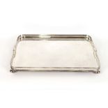 A large electro plated galleried drinks tray, raised on ball feet, 62cm