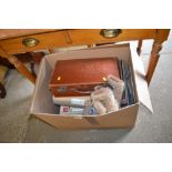 A box containing LP's; old newspapers; a brown lea