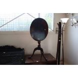 A mahogany tilt top table raised on tripod base