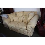 A gold floral upholstered two seater settee