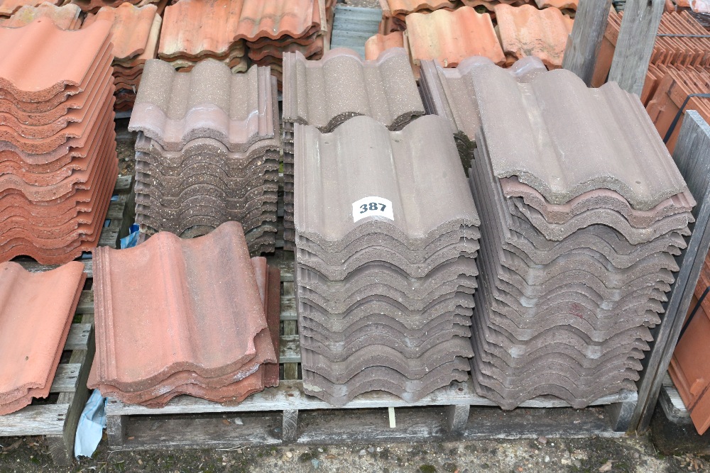 A pallet of grey and red roof tiles