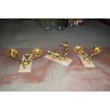 Three twin branch brass wall lights