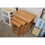 A nest of three light oak occasional tables