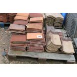 A pallet of peg tiles and concrete roof tiles