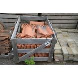 A crate of terracotta shaped roofing tiles