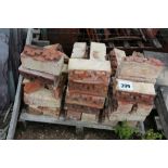 A pallet of ornate bricks - red