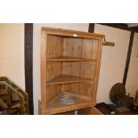 A stripped pine hanging corner cupboard